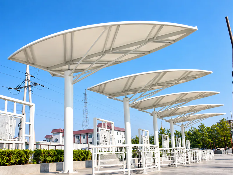 Row of leaf-shaped white tensile canopies shading a pedestrian walkway