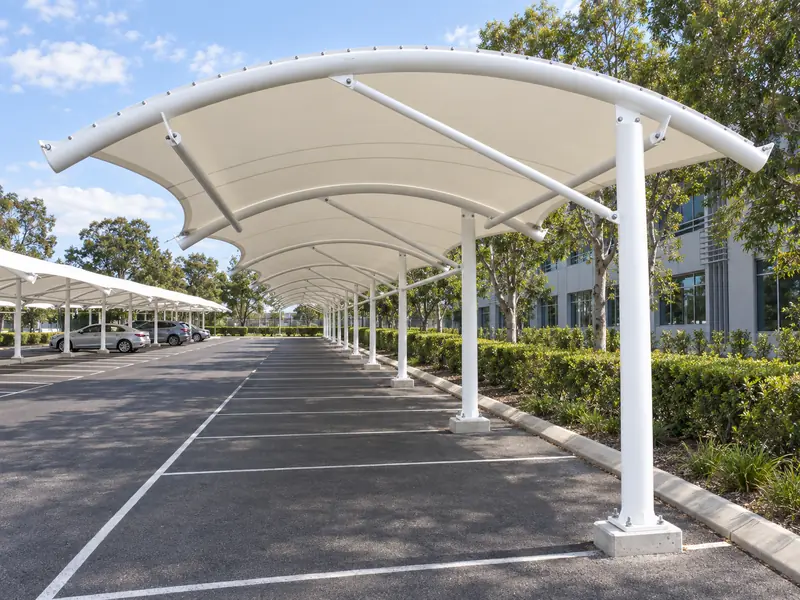 White tensile canopy shading marked car parking bays