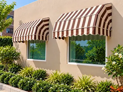 Brown and cream striped window awnings above two windows on a beige exterior wall