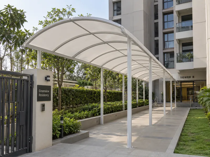 White arched fabric pathway canopy on steel posts leading from a society gate to a tower entrance