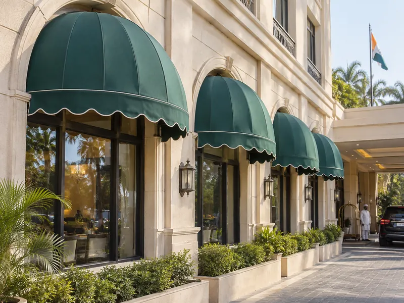 Quarter-round dome awnings in matching fabric over arched windows of a hotel front