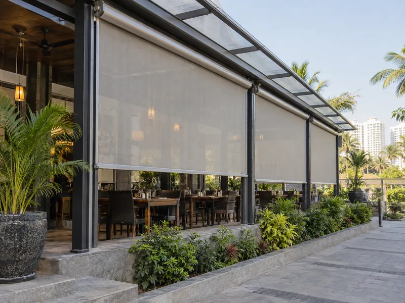 Fabric vertical drop awnings lowered along the open side of a restaurant veranda