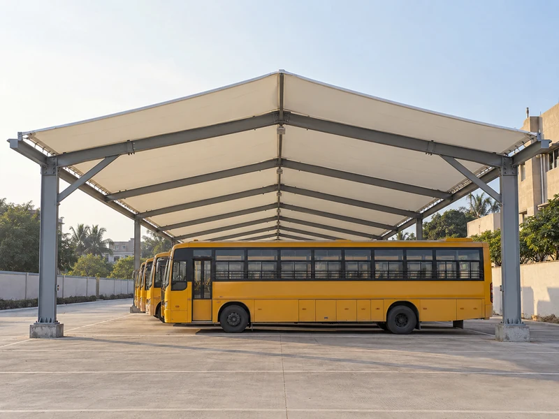 Tall wide-span parking shed over a row of school buses with columns only at the outer edges