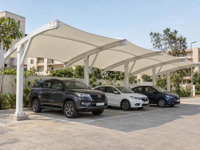 Repeated fabric parking canopy modules with steel perimeter beams and bolted connections