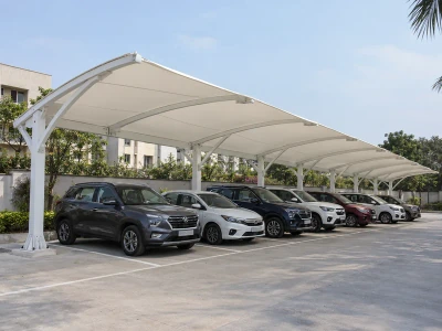Continuous fabric parking roof on repeated steel frames above a row of cars