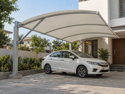 White fabric carport on braced rear steel columns beside a villa