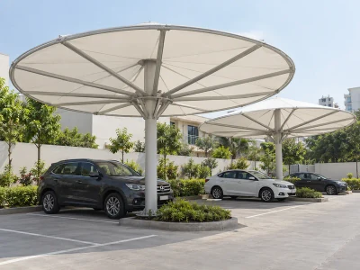 Circular umbrella parking roofs with radial steel ribs and central masts between car bays