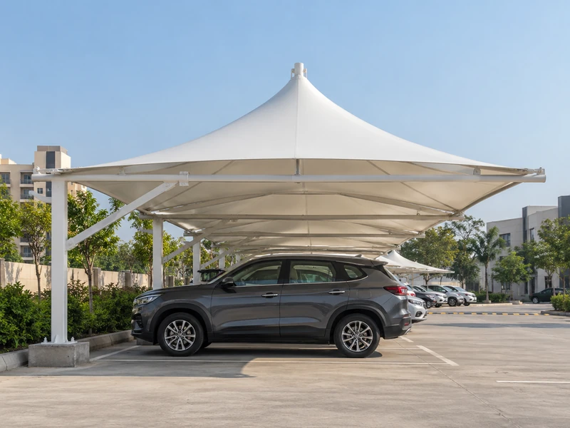 Row of white fabric cones over parking bays, each cone covering two cars, with columns between the bays