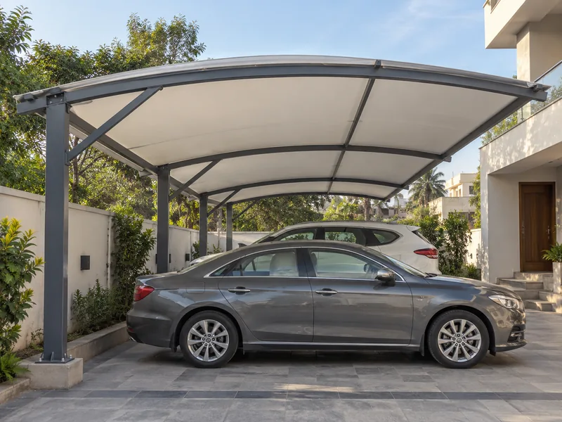 Column-free fabric parking shade over two cars side by side in a house forecourt