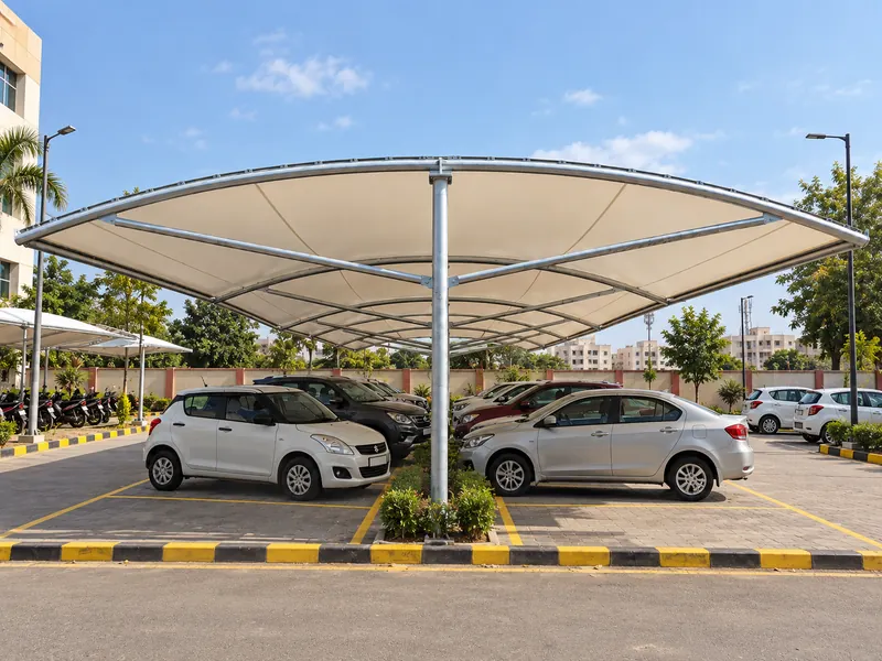 Front view of a double-sided tensile parking canopy with central steel posts and cars parked on both sides