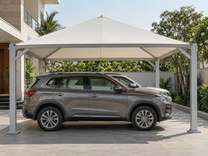 Square pyramid-shaped fabric shade on four corner columns over two cars in a villa forecourt