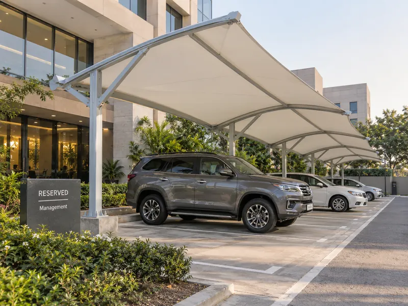 Reserved single parking bay with a fabric shade and a name board outside an office entrance
