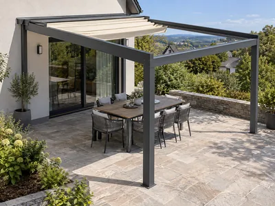Retractable pergola with a partly folded cream fabric roof above an outdoor dining table