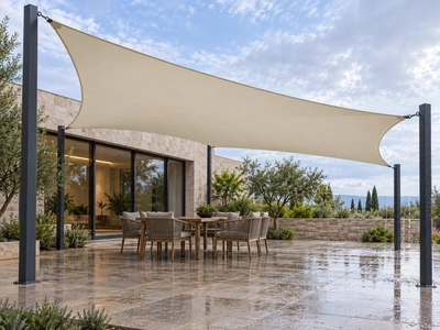 Sloping ivory shade sail over courtyard seating after rain