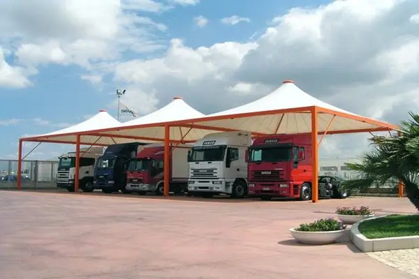 A large vehicles parked under a bus parking shade canopy, providing shelter the from weather conditions.