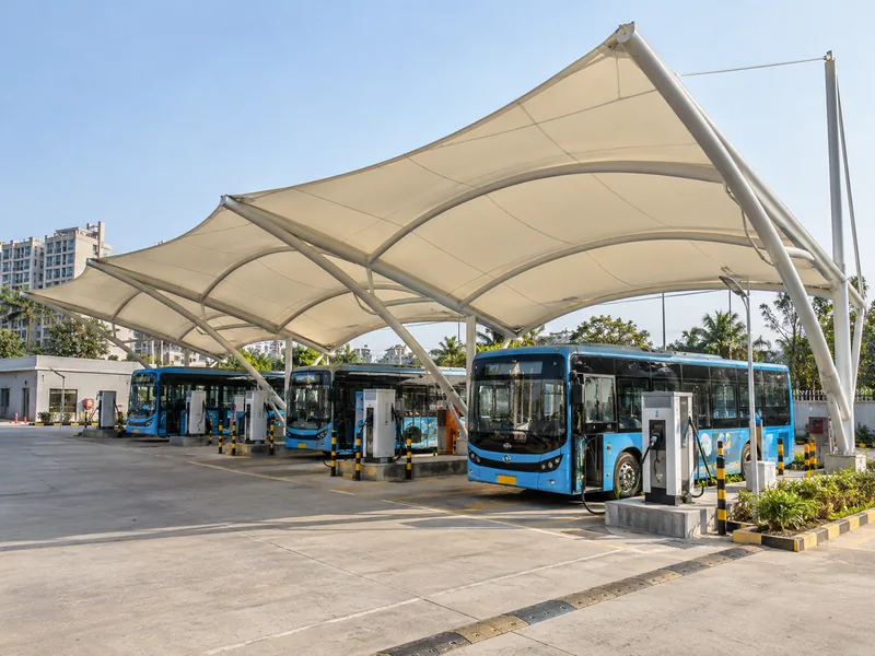High tensile roof over electric bus charging bays at a depot with chargers on raised plinths