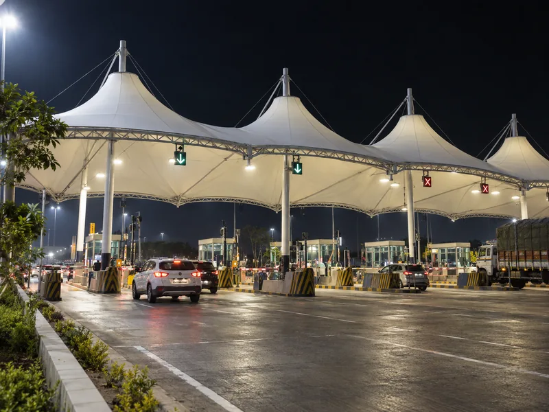 Toll plaza membrane roof at night with lane lights and lane signs fixed under the fabric