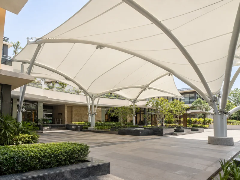 White fabric roof glowing with soft daylight over a covered courtyard with no lights switched on