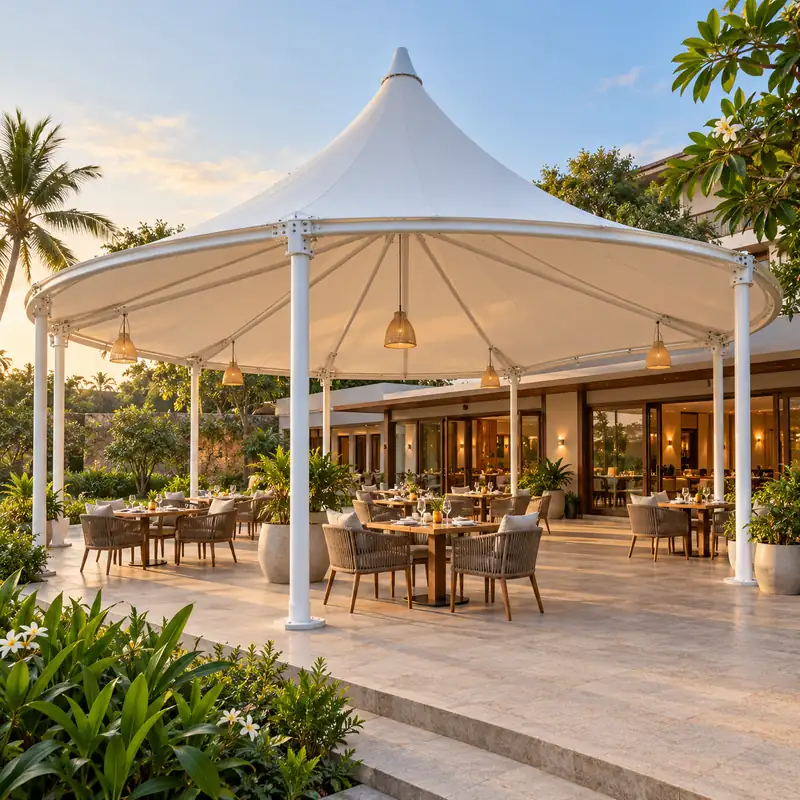 White conical tensile canopy over an outdoor resort dining terrace